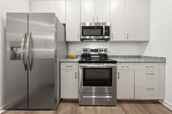 A modern kitchen with a stainless steel refrigerator and oven.