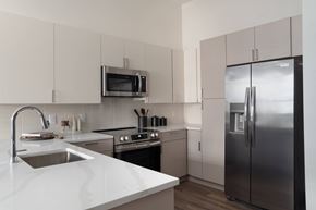 Cleveland apartment for rent - A modern kitchen with a stainless steel refrigerator and white countertops.