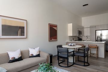 Cleveland apartment for rent - A living room with a grey couch and a dining table with chairs.