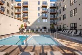 Cleveland apartment for rent - A large outdoor swimming pool surrounded by wooden decking and lounge chairs.