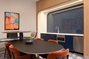 Cleveland apartment for rent - A modern dining room with a round table and orange chairs.