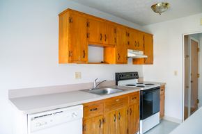 Lyndhurst apartment for rent - a kitchen with white appliances and wooden cabinets