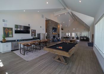 A large living room with a pool table and a television