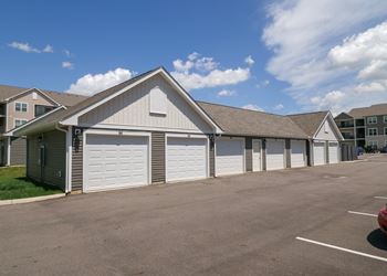 A building with white garage doors in front of an empty parking lot