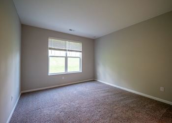 An empty room with carpet and a window