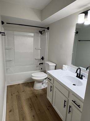Columbus apartment for rent - A white toilet is in a bathroom with wood floors.
