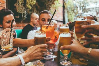 A group of people sitting around a table drinking beer