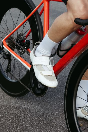 A person riding a bike with a white shoe on the pedal