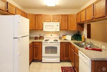 Columbus apartment for rent - A kitchen with wooden cabinets and white appliances.