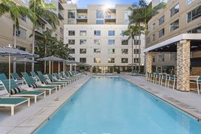Los Angeles apartment for rent - A long rectangular pool with lounge chairs on either side.