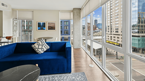 Denver apartment for rent - A blue couch sits in a living room with a view of the city.