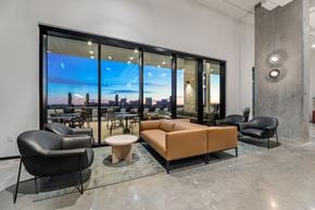 Houston apartment for rent - A modern living room with a large window overlooking a cityscape.