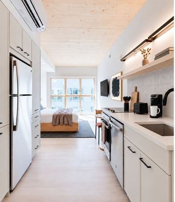 Charlotte apartment for rent - A modern kitchen with white appliances and wooden accents.