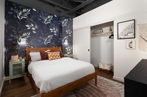 Phoenix apartment for rent - A bedroom with a large bed and a wallpapered wall.