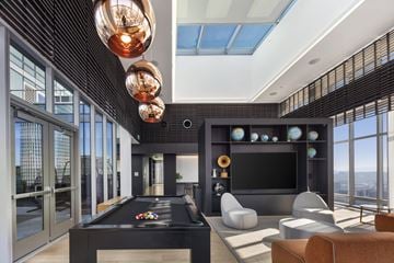 San Francisco apartment for rent - A modern living room with a pool table and a view of the city.