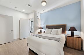 Austin apartment for rent - A bedroom with a large bed and a wooden nightstand.