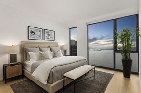 Seattle apartment for rent - a bedroom with a bed and a large window overlooking a body of water