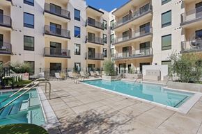 Scottsdale apartment for rent - A large swimming pool is surrounded by apartment buildings.