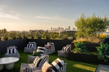 Alameda apartment for rent - A patio with black and white striped cushions and a view of the city skyline.