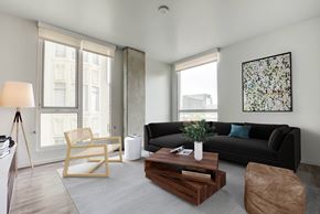 San Francisco apartment for rent - Open living room at Vance in San Francisco, CA.ch, wooden coffee table, and a large window.
