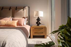 Toronto apartment for rent - a bedroom with a bed with pink pillows and a nightstand with a lamp
