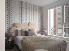 North York apartment for rent - A bedroom with a large bed and a window overlooking a building.
