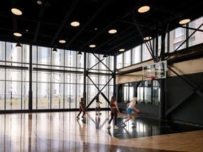 North York apartment for rent - A basketball game is in progress in a spacious gym.