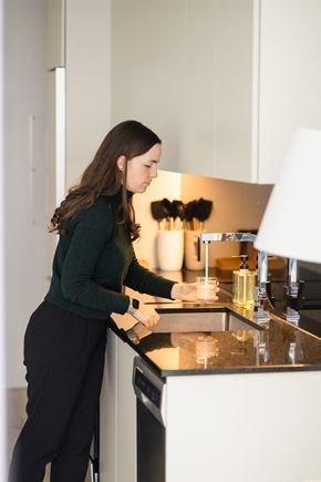 Montréal apartment for rent - A woman is washing dishes in a modern kitchen.