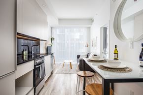 Montréal apartment for rent - A modern kitchen with a black countertop and stainless steel appliances.