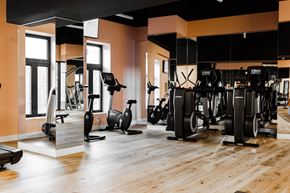 Montreal apartment for rent - a gym with exercise machines and weights on a wooden floor