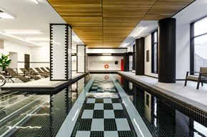 Montreal apartment for rent - a large swimming pool with chairs in a lobby