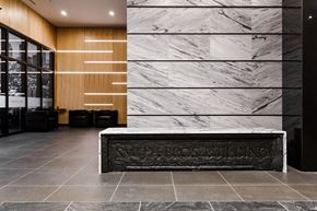 Montreal apartment for rent - a reception desk in the lobby of a building with marble walls