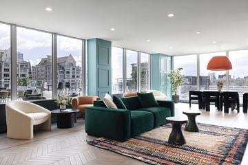 Montréal apartment for rent - A living room with a green couch and a white chair.