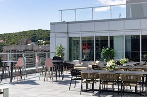 Montréal apartment for rent - A patio with chairs and tables is set up outside a building.