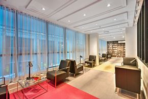 Montreal apartment for rent - A waiting room with a red carpet and black chairs.