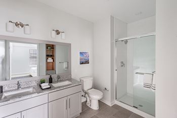 Elegant bathrooms featuring granite countertops and glass-enclosed soaking tubs