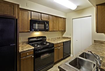 Orlando apartment for rent - a kitchen with black appliances and granite counter tops