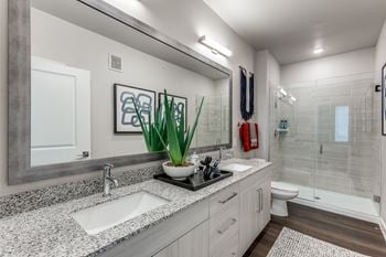 Elegant bathrooms featuring granite countertops, vanity sconces and glass showers or soaking tubs