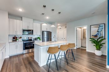 Chef-inspired kitchens featuring stainless steel appliances, custom cabinetry with 42” wall cabinets, granite countertops, and tile backsplash