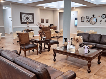 Houston apartment for rent - A living room with brown leather furniture and a large clock on the wall.
