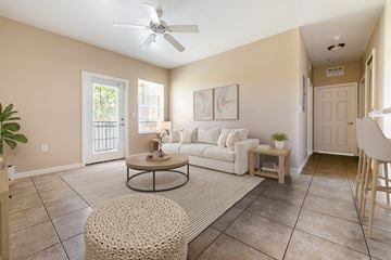 Riverview apartment for rent - A living room with a white couch and a round ottoman.