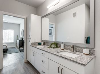 Elegant bathrooms featuring double-sink vanities, granite counters, and glass showers or soaking tubs