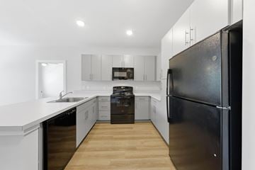 Old Bridge apartment for rent - A black refrigerator is in the corner of a white kitchen.