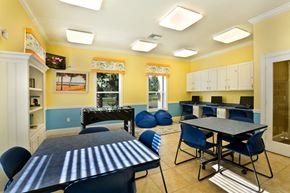 Jacksonville apartment for rent - a recreation room with tables and chairs and a foosball table