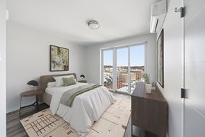 Norwalk apartment for rent - A bedroom with a large bed and a view of the outside.