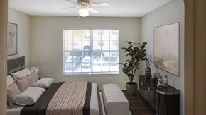 Jacksonville apartment for rent - a bedroom with a bed and a window and a ceiling fan