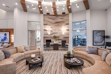 Boca Raton apartment for rent - A modern living room with a large couch, a coffee table, and a large painting on the wall.