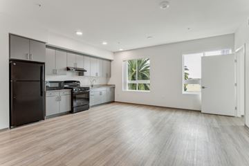 Los Angeles apartment for rent - A spacious kitchen with a black refrigerator and wooden flooring.