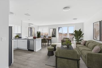 Norwalk apartment for rent - A modern kitchen with a dining table and chairs is adjacent to a living room with a couch and a coffee table.