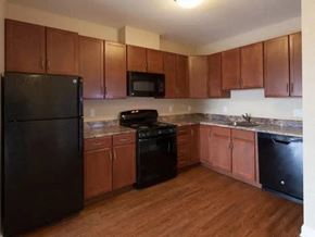 Tinton Falls apartment for rent - a kitchen with black appliances and wooden cabinets